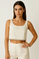 Top corto de breteles anchos, color crema, con escote redondo y detalle de pespunte en forma de ondas en el ruedo inferior.