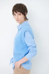 Chaleco de punto sin mangas, color azul, con cuello redondo y diseño de calce holgado.