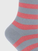 Calcetín de caña media con diseño de rayas horizontales en color gris y rosado. Presenta un borde superior con terminación ondulada y un pequeño bordado del icónico perro de la marca Hush Puppies.