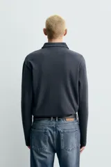 Polo de manga larga con corte regular fit, confeccionado en tejido de algodón con acabado cepillado. Presenta cuello solapa y cierre frontal con botonadura.