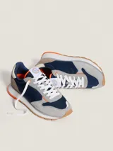 Championes Hoff modelo Delos, con base blanca y suela color caramelo. Capellada combinada en gris, azul marino y naranja.