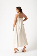 Vestido largo color crudo, de corte recto y breteles finos.