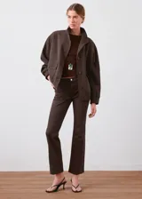 Jeans Sienna de corte recto y tiro medio, en color marrón oscuro, con bolsillos tradicionales y cierre frontal con botón y cremallera.