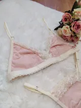 Conjunto de lencería compuesto por un corpiño triangular y una bombacha tipo tanga, confeccionados en algodón color salmón con detalles de puntilla en tono champagne.