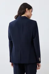 Blazer azul marino de corte clásico, con solapa de muesca, un botón dorado frontal y bolsillos de solapa.
