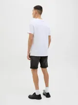 Bermuda de jean color gris oscuro con efecto lavado, de corte recto y largo hasta las rodillas, con dobladillo vuelto en los puños y bolsillos clásicos.