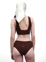 Top de bikini color marrón oscuro, con escote en V profundo y tirantes anchos, confeccionado en tejido acanalado.