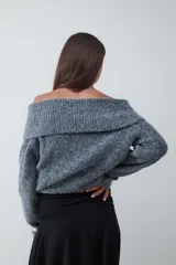 Sweater de punto tricot con diseño off-shoulder, de calce relajado y mangas largas. Presenta una textura suave y flexible con cuello amplio que cae sobre los hombros.