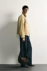 Cazadora regular fit de cuero con acabado de ante en color beige, con cuello solapa, bolsillos de plastrón en la cadera y cierre frontal de cremallera oculta por solapa con botones a presión.