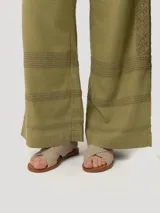 Pantalón de tiro alto con corte recto, confeccionado en mezcla de lino y viscosa. Presenta un diseño sofisticado con ajuste lateral mediante hebillas metálicas y bolsillos laterales.