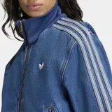 Campera Adidas modelo Firebird confeccionada en tejido denim de algodón. Presenta cierre frontal de cremallera, cuello alto, puños y ruedo en tejido rib elástico. Incluye las icónicas tres franjas en las mangas y el logo del trébol bordado en el pecho.