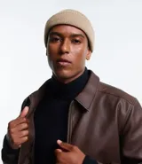 Gorro tipo fisherman de tejido acrílico con textura acanalada, diseño corto y etiqueta pequeña con logo en el frente.