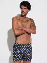 Bóxer de algodón blanco con estampado de flores pequeñas color celeste, con cintura elástica y logo de la marca en el centro.