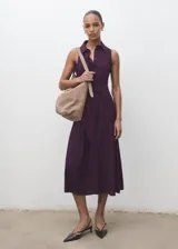 Vestido midi color borravino, sin mangas, con cuello camisero, cierre frontal con botones y cinturón ajustable del mismo tejido.