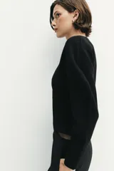 Chaqueta de punto de manga larga con cuello redondo y cierre frontal asimétrico con botones.
