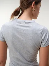 Remera de manga corta y corte al cuerpo, con cuello a la base.