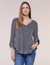 Remera de calce relajado y silueta fluida, con escote en V y mangas tres cuartos con presilla y botón. Diseño de rayas dispuestas en ángulo tipo espiga en el delantero y ruedo redondeado.