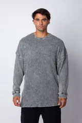 Buzo de corte oversize confeccionado en tela waffle de algodón con proceso de teñido acid wash. Presenta cuello redondo con detalle de costura en X y mangas largas con puños acanalados.