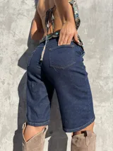 Bermuda de denim azul oscuro con bolsillos traseros y costuras en contraste.