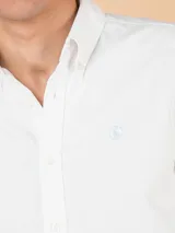 Camisa de hombre Oxford a rayas rosadas y blancas, con corte regular fit, cuello button-down, mangas largas, cierre frontal de botones y logo bordado en el pecho.
