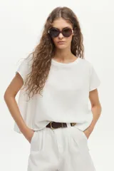 Blusa de lino color blanco, con cuello bote y mangas cortas de corte holgado.