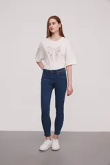 Pantalón jean de corte skinny y tiro medio, con diseño clásico de cinco bolsillos y costuras reforzadas.