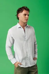 Camisa de manga larga para hombre, color azul claro jaspeado, con cuello clásico y botones blancos. Corte ajustado (slim fit).