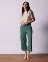 Pantalón capri plisado color beige, marca Dictionary, con pretina ancha elastizada y bolsillos delanteros.