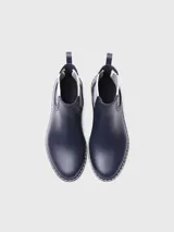 Botas de agua de caña baja color bordó, con elásticos laterales a rayas en tonos burdeos, beige y marrón. Cuenta con suela dentada negra, costuras blancas decorativas en el borde y presilla trasera para facilitar el calce.