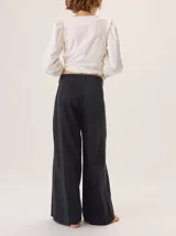 Pantalon de pierna ancha color azul marino, con costuras decorativas en contraste de color rojo y franjas laterales a tono. Cuenta con cintura alta, cierre frontal y bolsillos laterales.