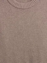 Buzo de tejido suave color taupe, con cuello redondo y puños y ruedo acanalados con diseño de volado en la cintura.