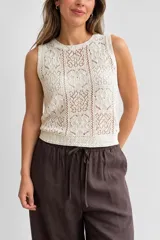 Musculosa tejida color natural, sin mangas, con escote redondo y trama calada de diseño geométrico y floral.