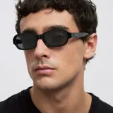 Lentes de sol con montura rectangular de bordes redondeados en color negro brillante. Cuentan con lentes polarizadas oscuras con protección UV400.
