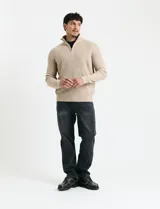 Sweater de punto inglés color verde, con cuello alto y cierre frontal parcial metálico. Diseño de manga larga con puños y ruedo acanalados.