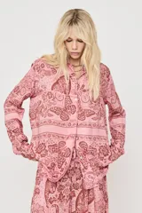 Camisa oversize rosada con estampado de mariposas y motivos florales, de manga larga y cierre frontal de botones.