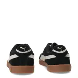 Championes urbanos Puma Club II Era Suede, con exterior de gamuza negra, franja lateral característica en color blanco y suela de goma color caramelo. Presenta cierre con cordones y logo de la marca en dorado.