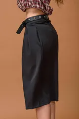 Bermuda de tiro alto color negro, con diseño amplio y tablas delanteras. Incluye un cinturón de cuero sintético con hebilla metálica y detalles de tachas plateadas.