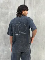 Remera gris con efecto lavado, corte oversize, manga corta y estampado pequeño en el frente.