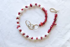 Gargantilla corta hecha a mano con perlas de río blancas y cuentas de coral rojo.