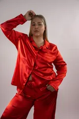 Pijama de seda rojo, compuesto por una camisa de manga larga con cuello solapa y botones frontales, y un pantalón largo a juego.
