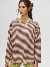 Remera manga larga a rayas horizontales marrones y beige, con cuello redondo verde y bordado en el frente.