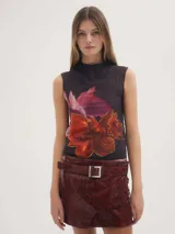 Musculosa negra con estampado floral en tonos rosados y naranjas.