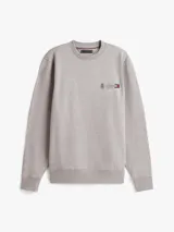 Buzo de cuello redondo Tommy Hilfiger en color gris melange, con diseño de logo y escudo bordados en el pecho. Presenta puños y ruedo acanalados.