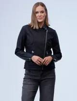 Campera de eco cuero negra, marca Baccini, con cuello con solapa y aplique de tachas. Abertura con cierre metálico cruzado, bolsillos y puños con cierre metálico y forro a tono.