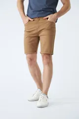 Bermuda clásica de jean color beige, con cinco bolsillos, cierre con cremallera y botón.