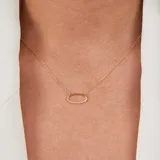 Conjunto de joyería en oro 18k compuesto por una cadena fina con dije ovalado engastado con brillantes y una gargantilla rígida minimalista.