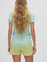 Short de punto tejido con patrón de rombos en tonos degradados de celeste y amarillo. Presenta una pretina elástica y un calce suelto.