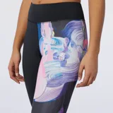 Calza larga deportiva New Balance Athletics, negra con estampado floral en tonos violeta, rosa y celeste en una pierna.