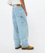 Pantalón de jean estilo carpenter con corte baggy relaxed, color azul claro. Cuenta con cintura con pasadores, cierre frontal con botón y bolsillos funcionales.