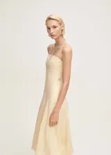 Vestido midi strapless de lino color beige, con diseño evasé y bajo abullonado.